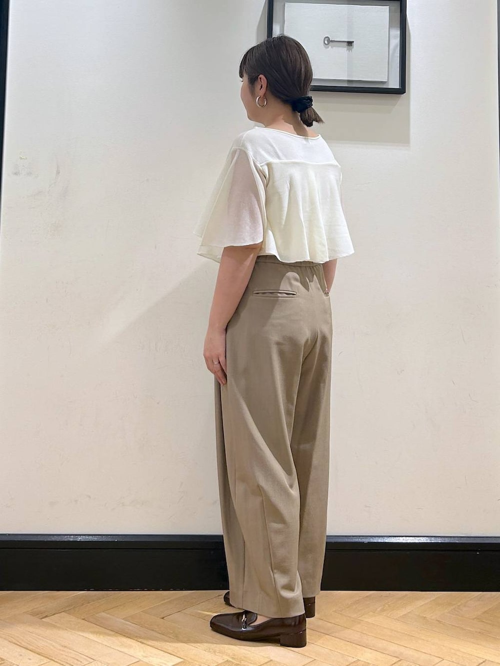 ベージュ系のスラックス、ブラウン系のローファー、ホワイト系のニット/セーターを着用したレディースの夏コーディネートの10枚目の写真