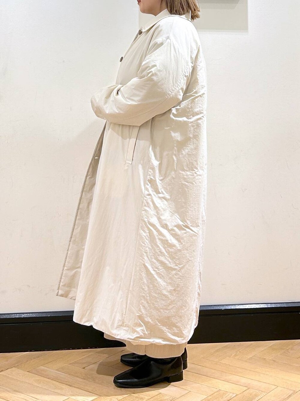 ブルー系のニット/セーター、ホワイト系のスカート、ホワイト系のダウンジャケット/コートを着用したレディースの秋コーディネートの4枚目の写真