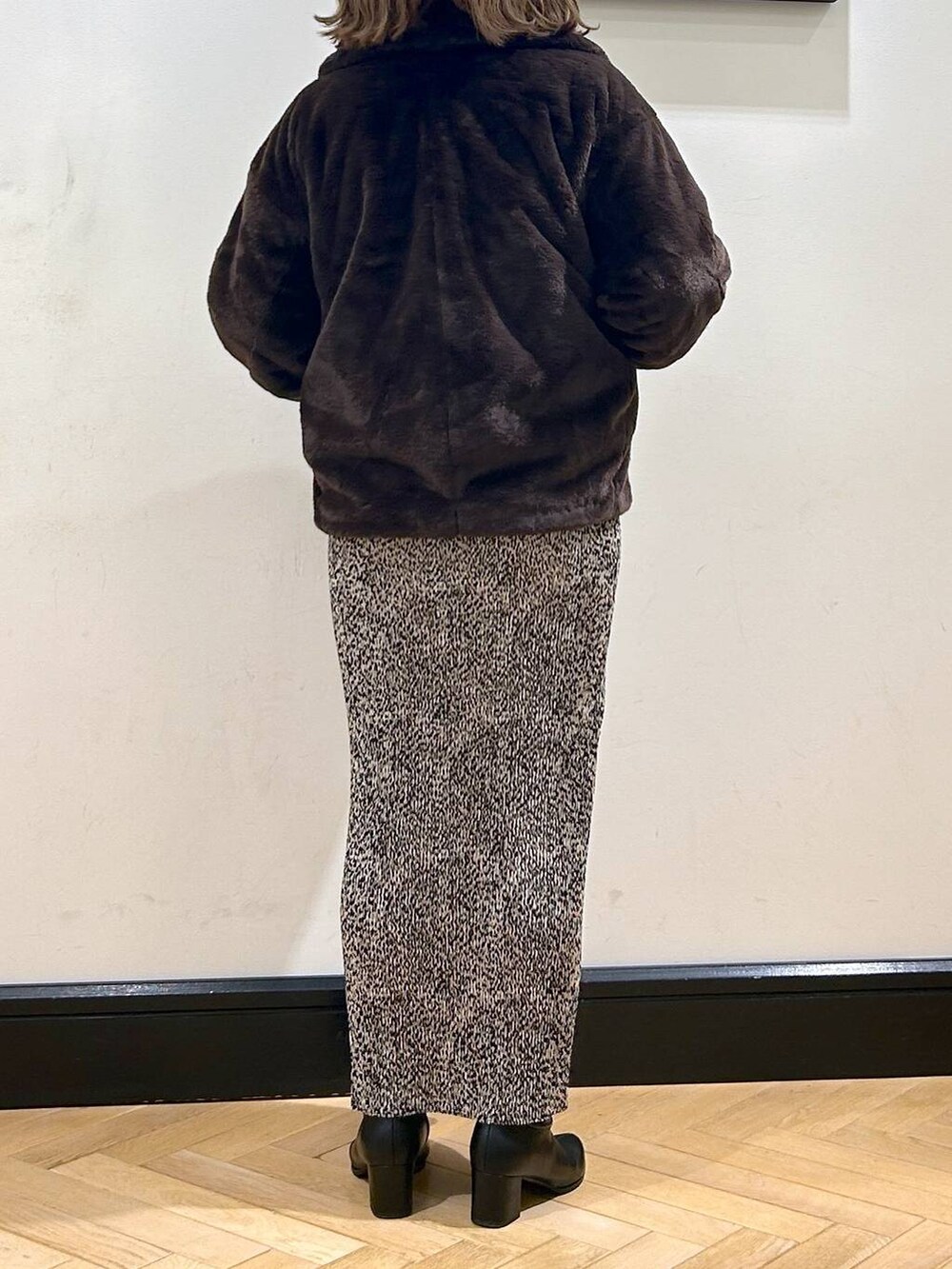 ブラック系のブーツ、ブラウン系のその他アウター、ホワイト系のカーディガン/ボレロを着用したレディースの秋コーディネートの6枚目の写真