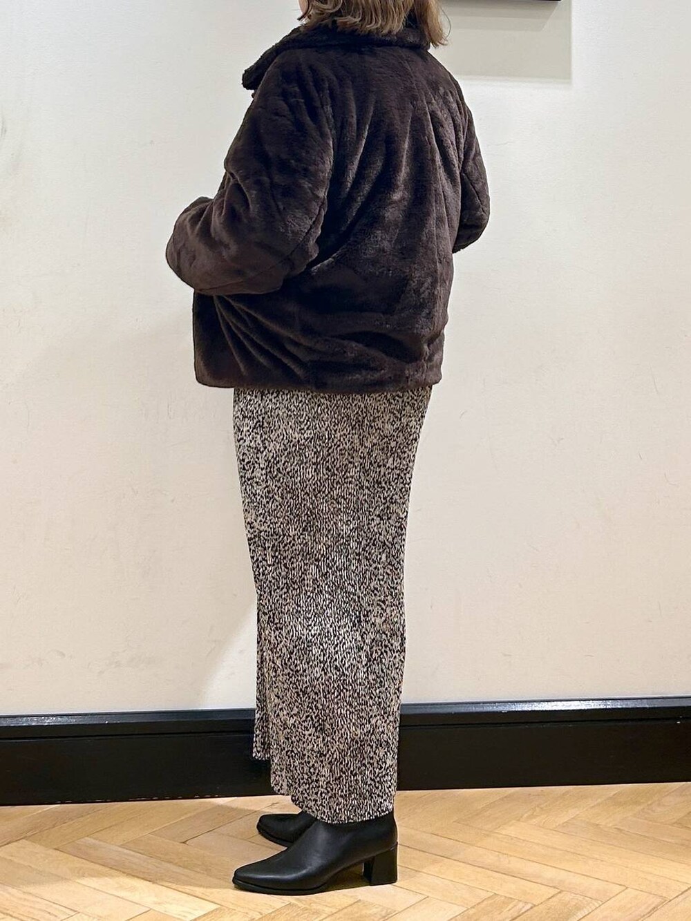 ブラック系のブーツ、ブラウン系のその他アウター、ホワイト系のカーディガン/ボレロを着用したレディースの秋コーディネートの5枚目の写真