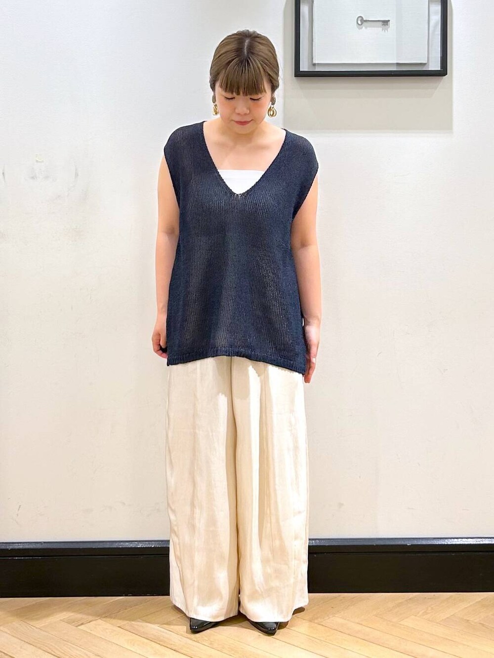 ブラック系のパンプス、ホワイト系のタンクトップ、ブラック系のボストンバッグを着用したレディースの夏コーディネートの6枚目の写真