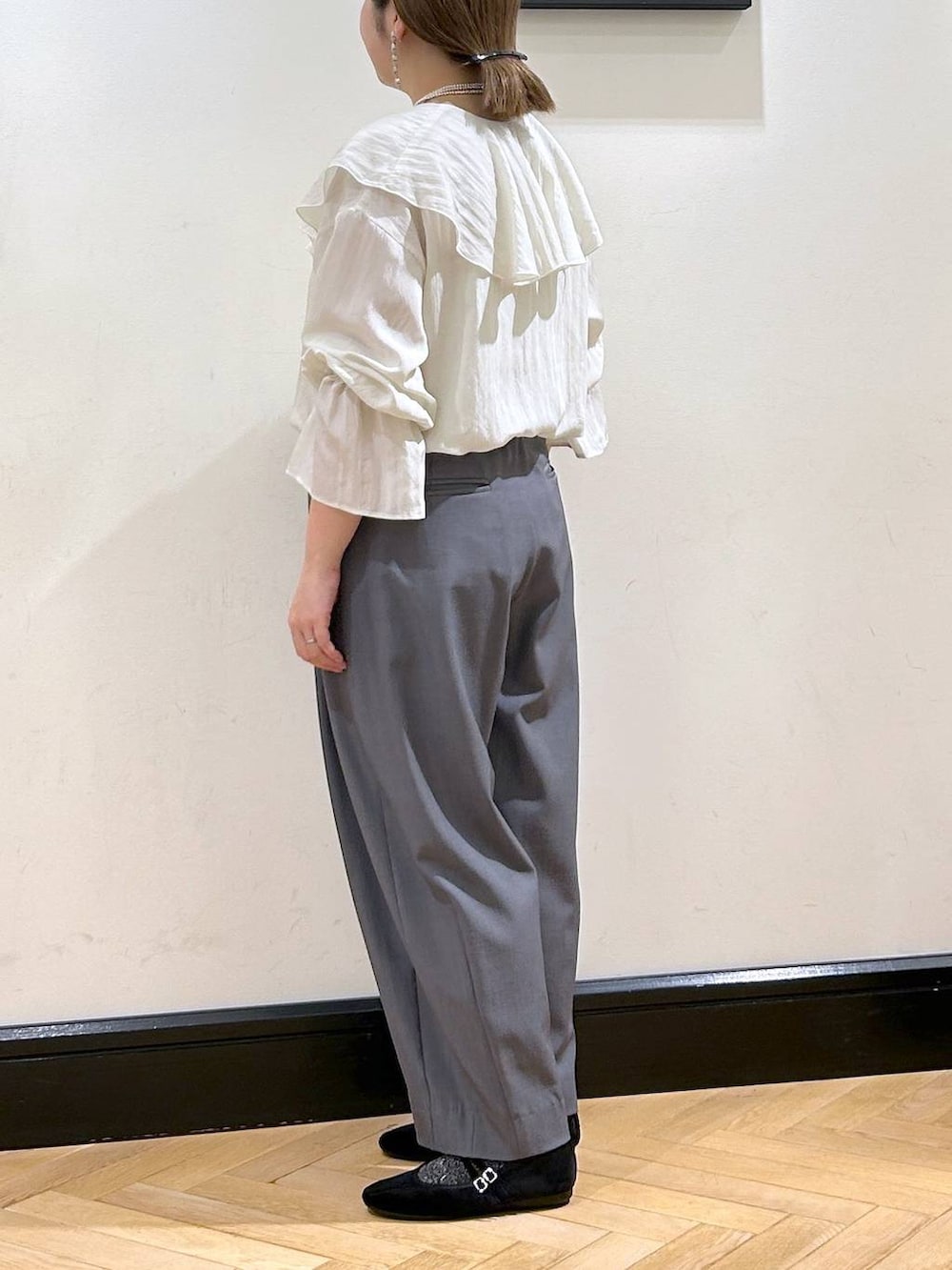 グレー系のスラックス、ブラック系のバレエシューズ、ホワイト系のシャツ/ブラウスを着用したレディースの秋コーディネートの7枚目の写真