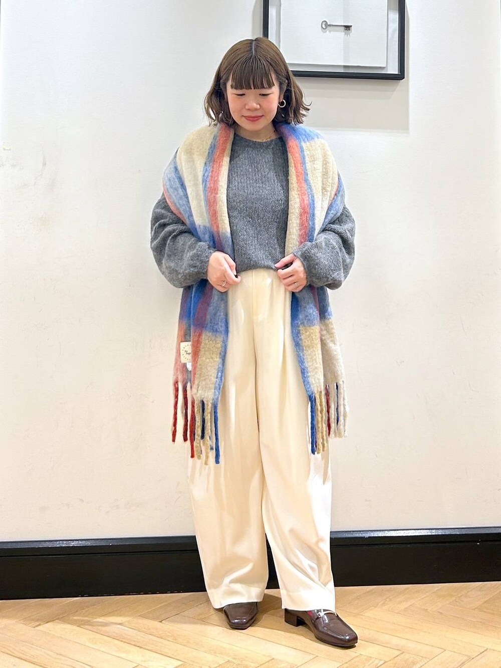 ホワイト系のスラックス、ブラウン系のローファー、グレー系のニット/セーターを着用したレディースの秋コーディネートの6枚目の写真