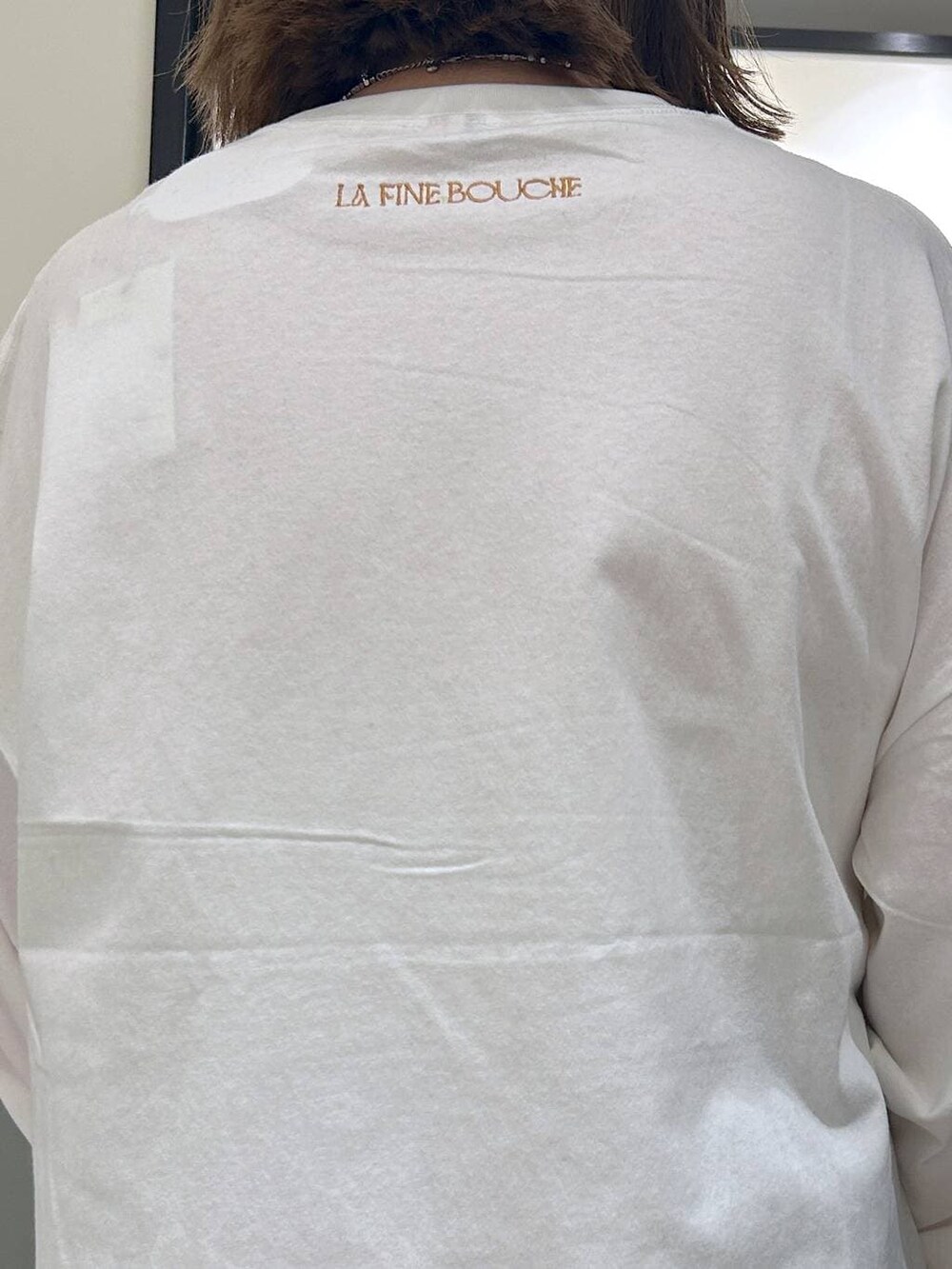 グレー系のスラックス、ホワイト系のTシャツ/カットソー、ブラック系のスリッポンを着用したレディースの秋コーディネートの7枚目の写真