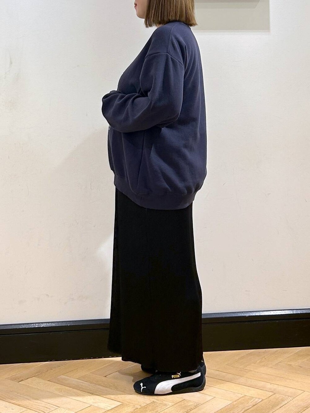 ブラック系のスニーカー、ブラック系のスカート、ブルー系のスウェットを着用したレディースの秋コーディネートの7枚目の写真