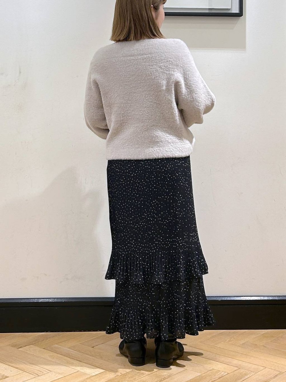 グレー系のスカート、ブラック系のブーツ、グレー系のニット/セーターを着用したレディースの冬コーディネートの6枚目の写真