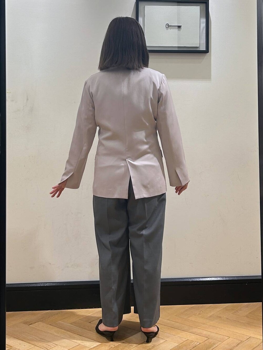 ブラウン系のパンプス、グレー系のノーカラージャケット、ブラック系のショルダーバッグを着用したレディースの夏コーディネートの7枚目の写真