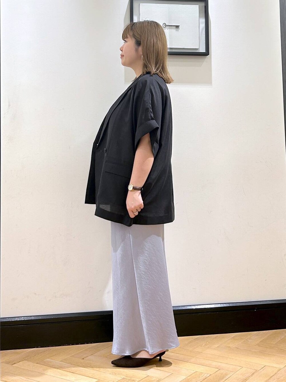 ブルー系のスカート、ブラウン系のパンプス、ホワイト系のシャツ/ブラウスを着用したレディースの夏コーディネートの6枚目の写真