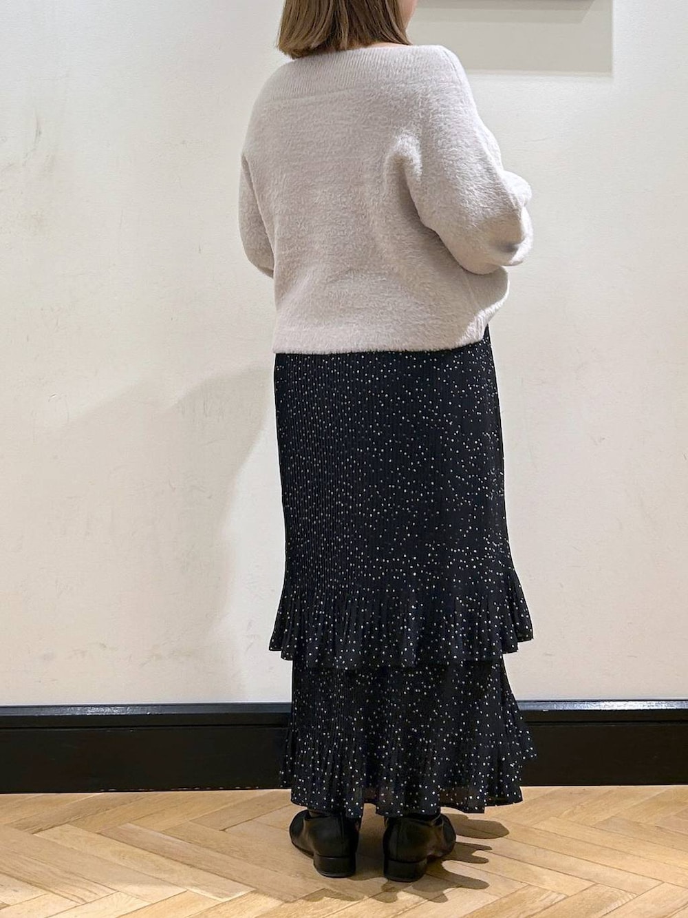 グレー系のスカート、ブラック系のブーツ、グレー系のニット/セーターを着用したレディースの冬コーディネートの5枚目の写真