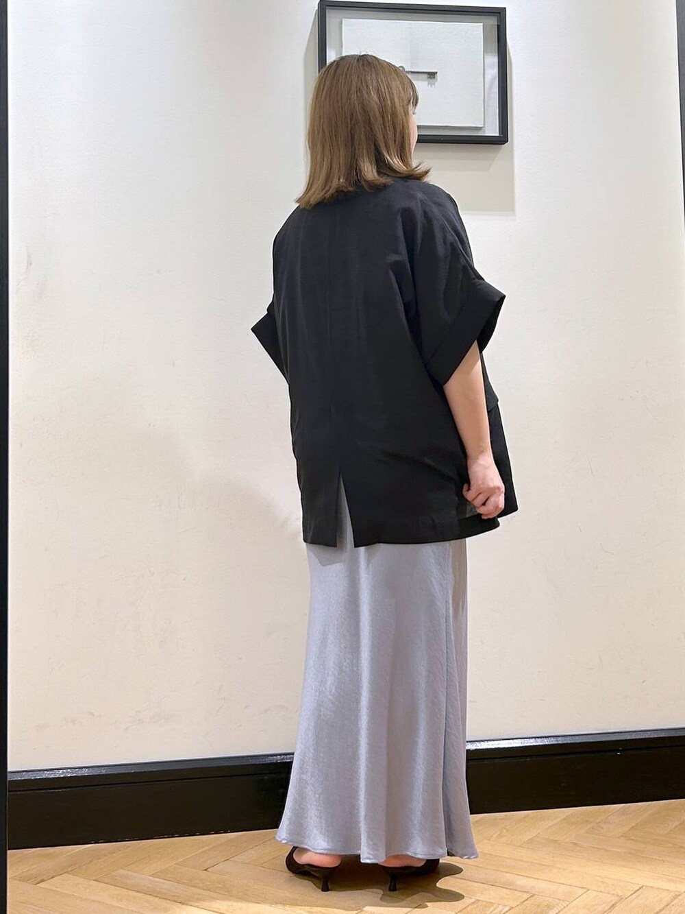 ブルー系のスカート、ブラウン系のパンプス、ホワイト系のシャツ/ブラウスを着用したレディースの夏コーディネートの8枚目の写真