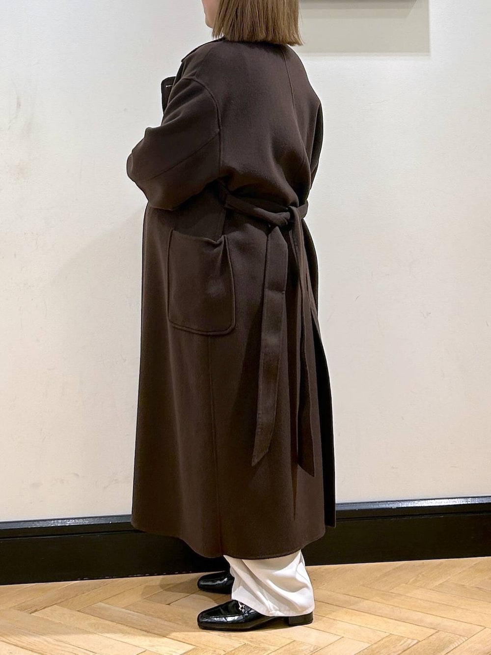 ブラウン系のステンカラーコート、ブラック系のローファー、ブルー系のニット/セーターを着用したレディースの秋コーディネートの5枚目の写真