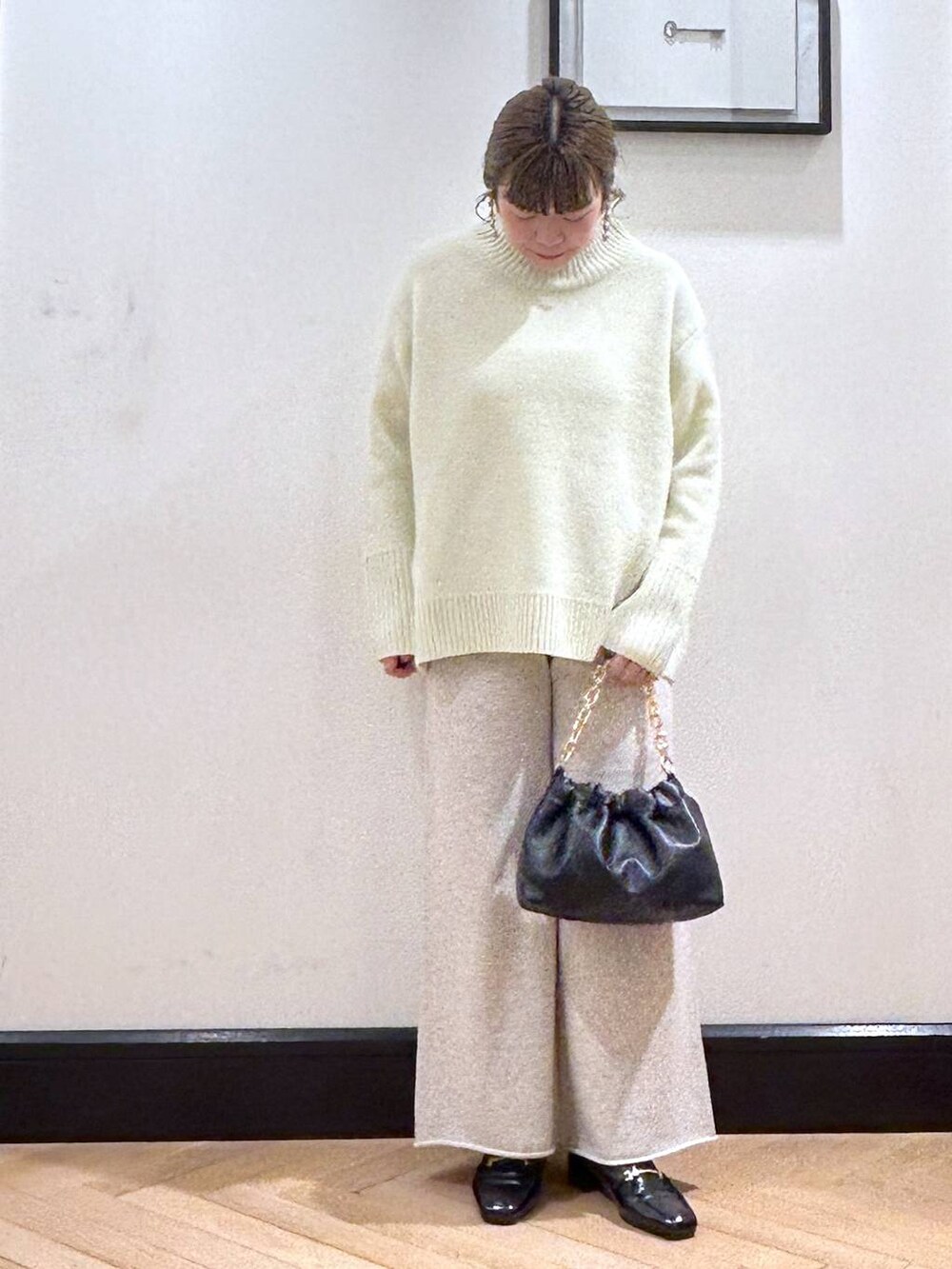 ブラック系のローファー、イエロー系のニット/セーター、ブラック系のショルダーバッグを着用したレディースの冬コーディネートの2枚目の写真