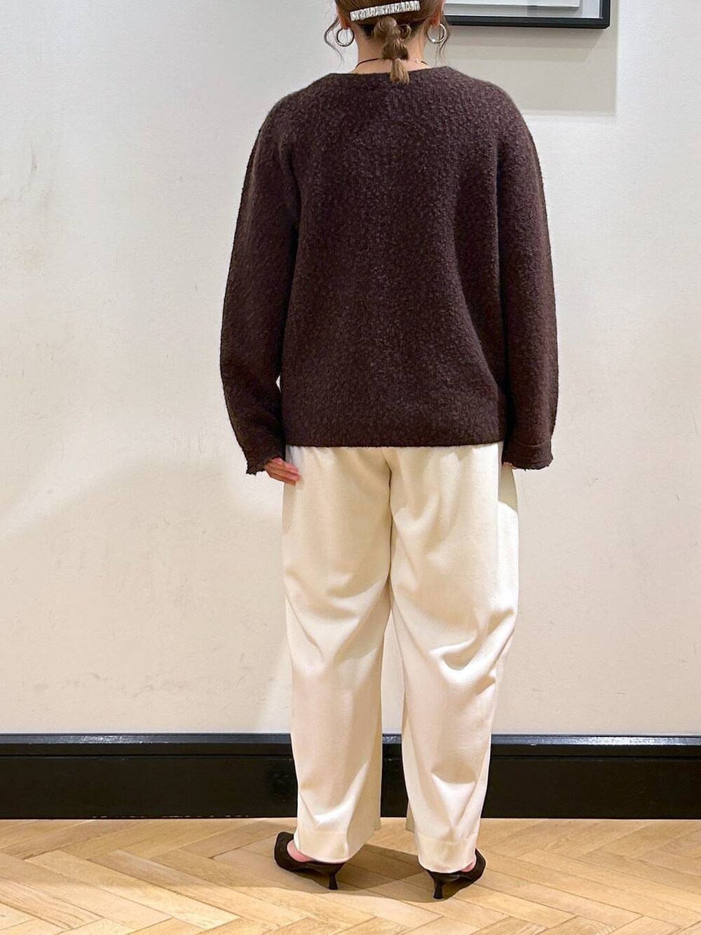 ホワイト系のスラックス、ブラウン系のパンプス、ベージュ系のショルダーバッグを着用したレディースの秋コーディネートの6枚目の写真