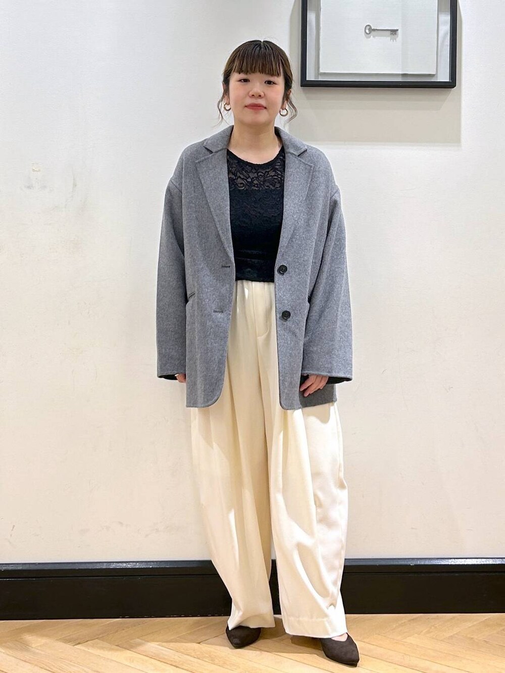 ホワイト系のスラックス、ブラウン系のパンプス、ブラック系のTシャツ/カットソーを着用したレディースの秋コーディネートの4枚目の写真