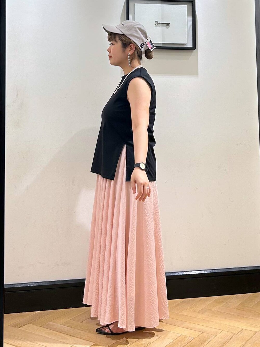 ブラウン系のサンダル、ブラック系のTシャツ/カットソー、ピンク系のスカートを着用したレディースの夏コーディネートの3枚目の写真