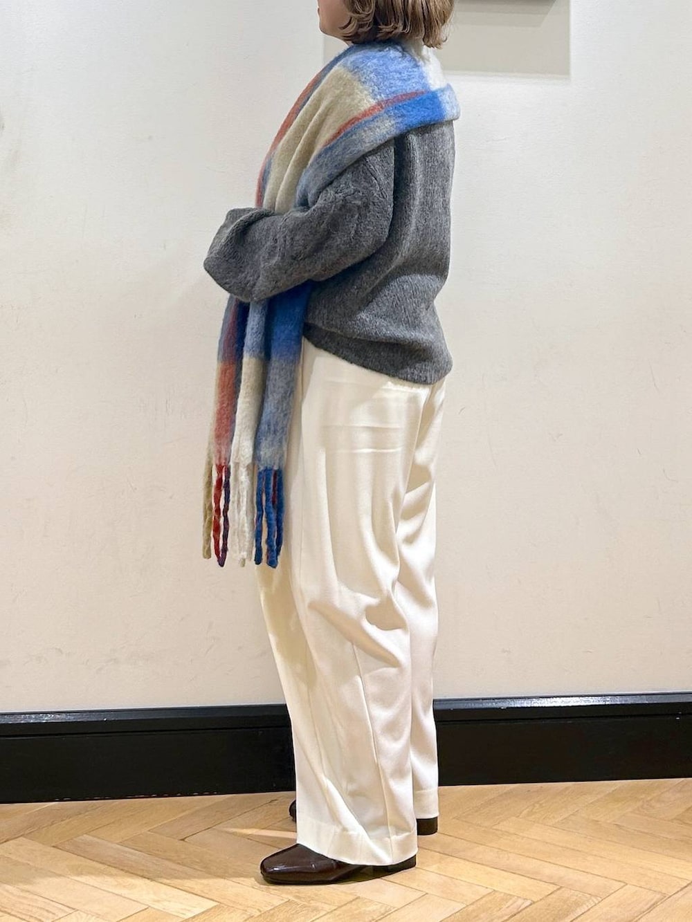 ホワイト系のスラックス、ブラウン系のローファー、グレー系のニット/セーターを着用したレディースの秋コーディネートの7枚目の写真