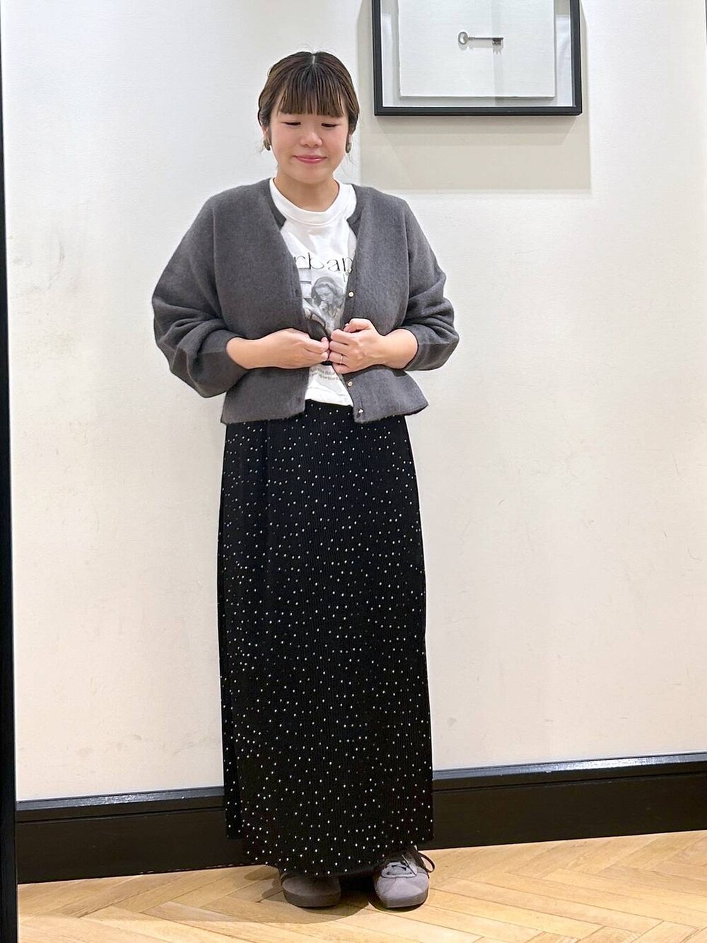 グレー系のカーディガン/ボレロ、その他のスカート、グレー系のスニーカーを着用したレディースの秋コーディネートの2枚目の写真