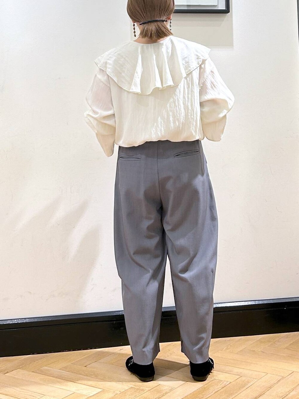 グレー系のスラックス、ブラック系のバレエシューズ、ホワイト系のシャツ/ブラウスを着用したレディースの秋コーディネートの6枚目の写真