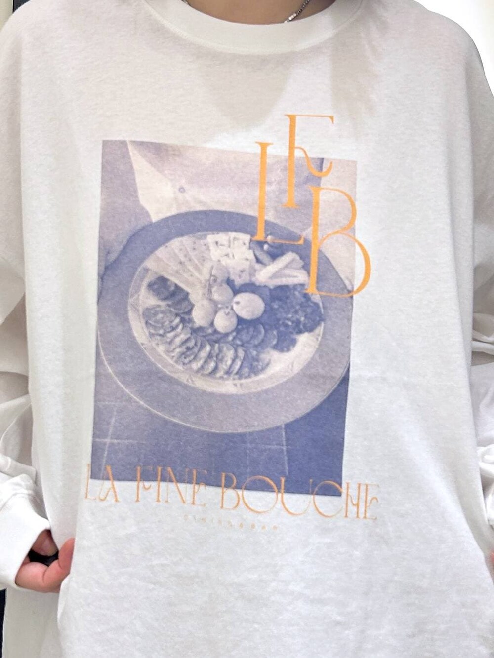 グレー系のスラックス、ホワイト系のTシャツ/カットソー、ブラック系のスリッポンを着用したレディースの秋コーディネートの6枚目の写真