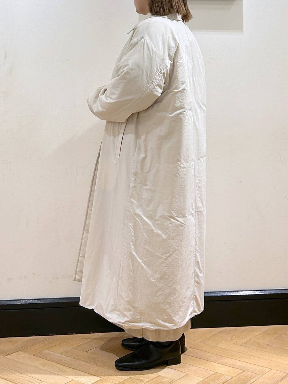 ブルー系のニット/セーター、ホワイト系のスカート、ホワイト系のダウンジャケット/コートを着用したレディースの秋コーディネートの5枚目の写真