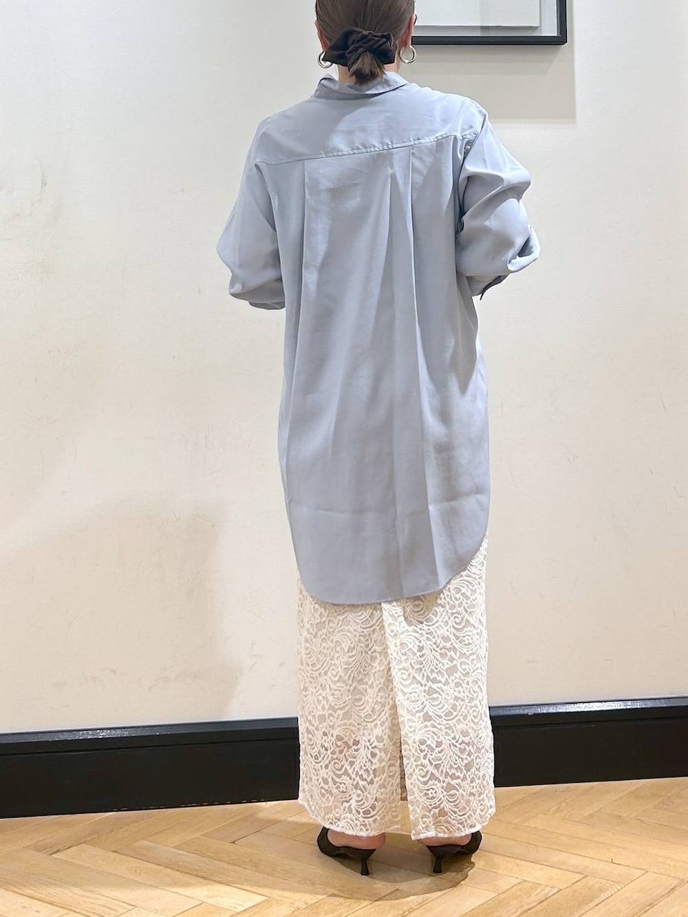 ブラウン系のパンプス、ホワイト系のスカート、ブルー系のシャツワンピースを着用したレディースの秋コーディネートの5枚目の写真