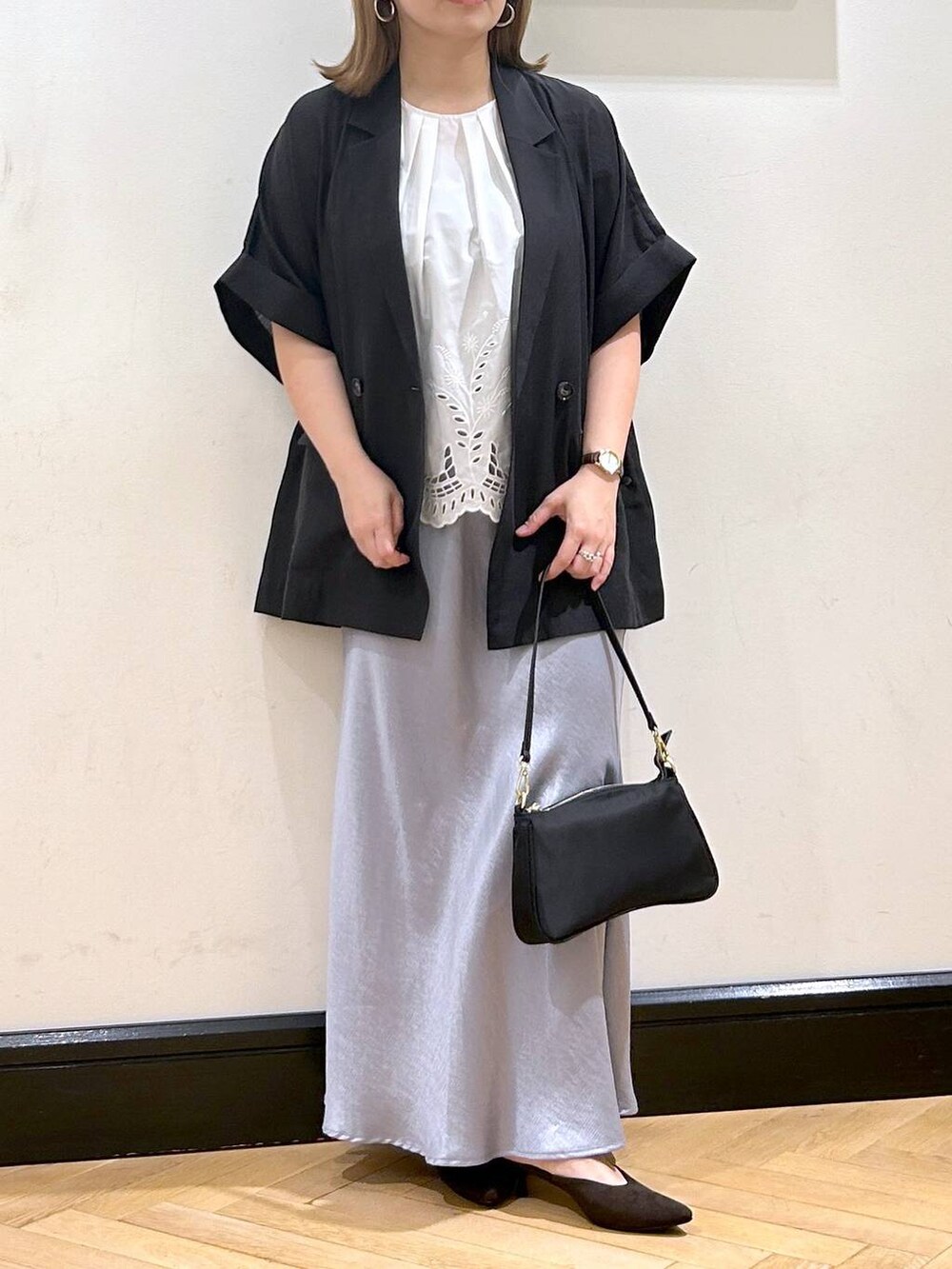 ブルー系のスカート、ブラウン系のパンプス、ホワイト系のシャツ/ブラウスを着用したレディースの夏コーディネートの5枚目の写真