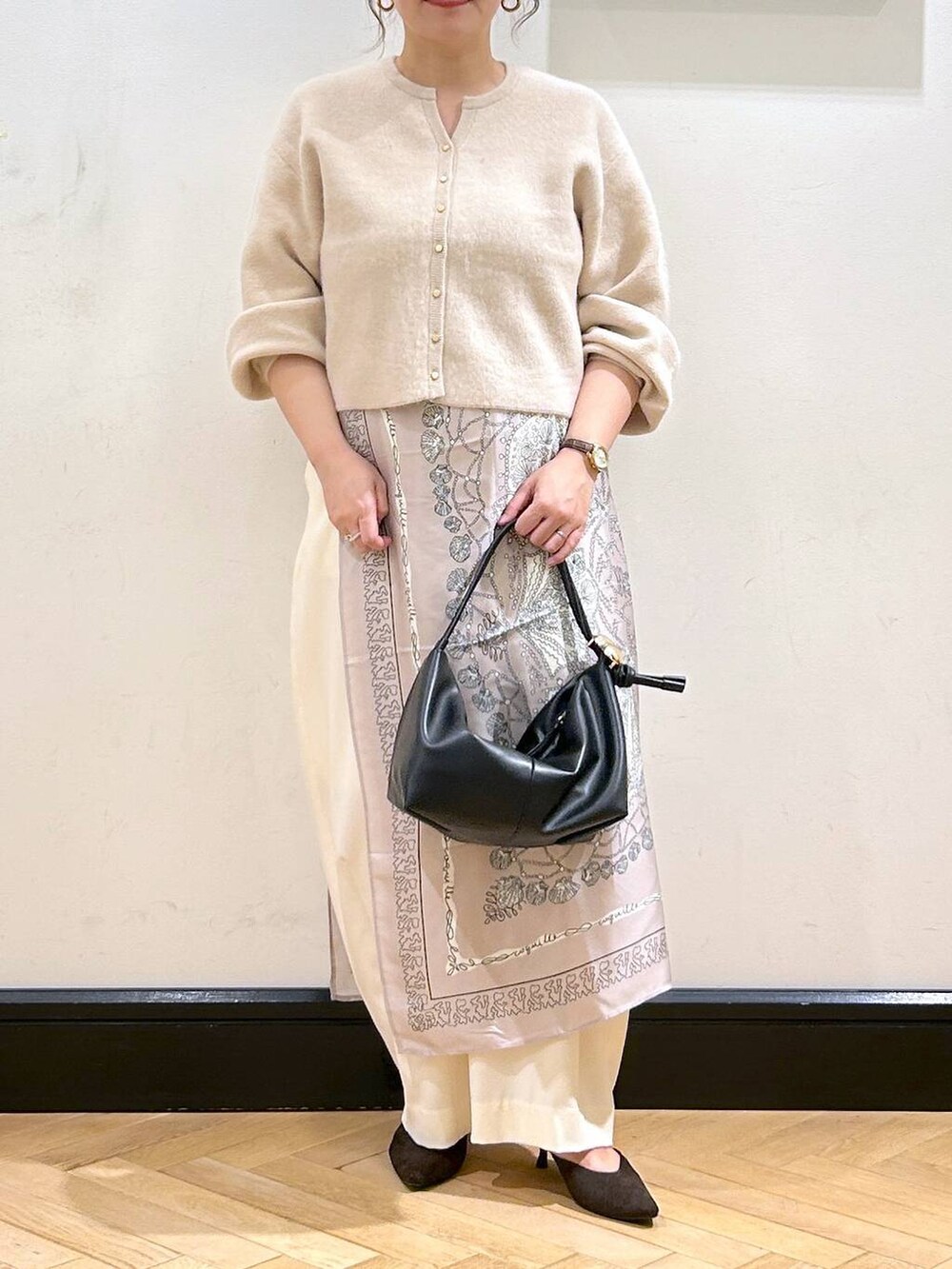 ホワイト系のスラックス、ホワイト系のカーディガン/ボレロ、ブラウン系のパンプスを着用したレディースの秋コーディネートの4枚目の写真