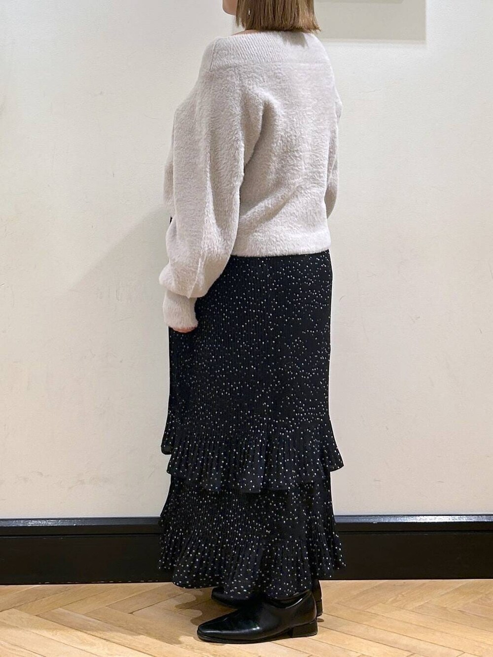 グレー系のスカート、ブラック系のブーツ、グレー系のニット/セーターを着用したレディースの冬コーディネートの3枚目の写真