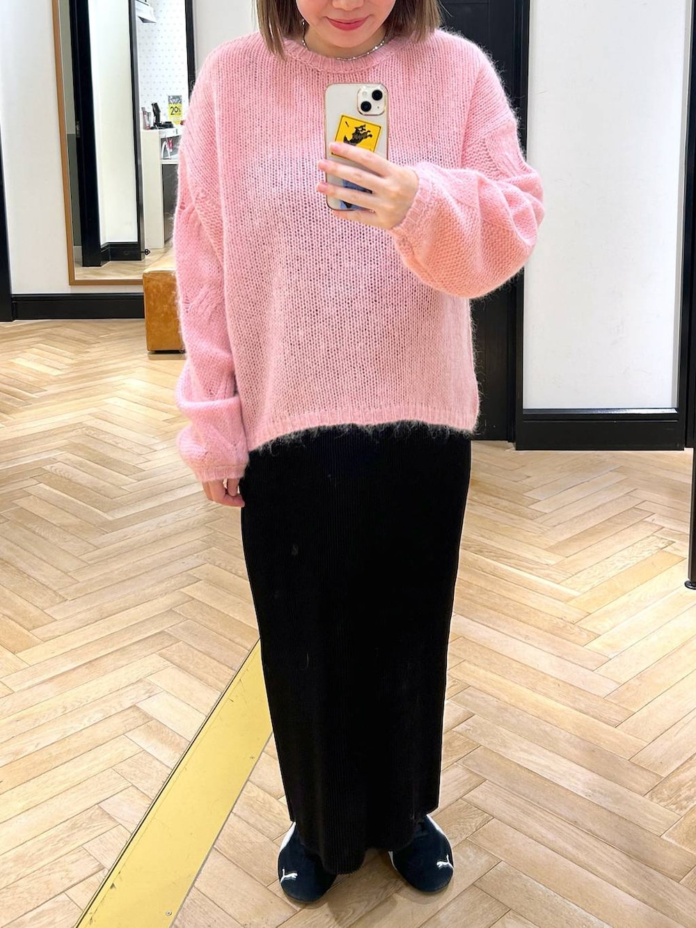 ブラック系のスニーカー、ブラック系のスカート、ピンク系のニット/セーターを着用したレディースの秋コーディネートの3枚目の写真