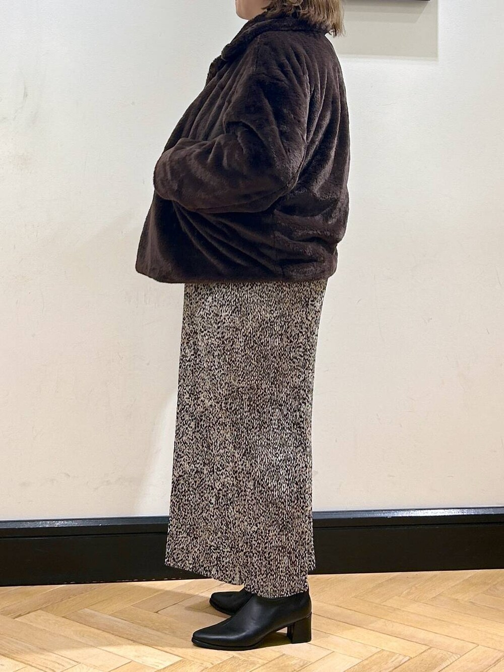 ブラック系のブーツ、ブラウン系のその他アウター、ホワイト系のカーディガン/ボレロを着用したレディースの秋コーディネートの4枚目の写真