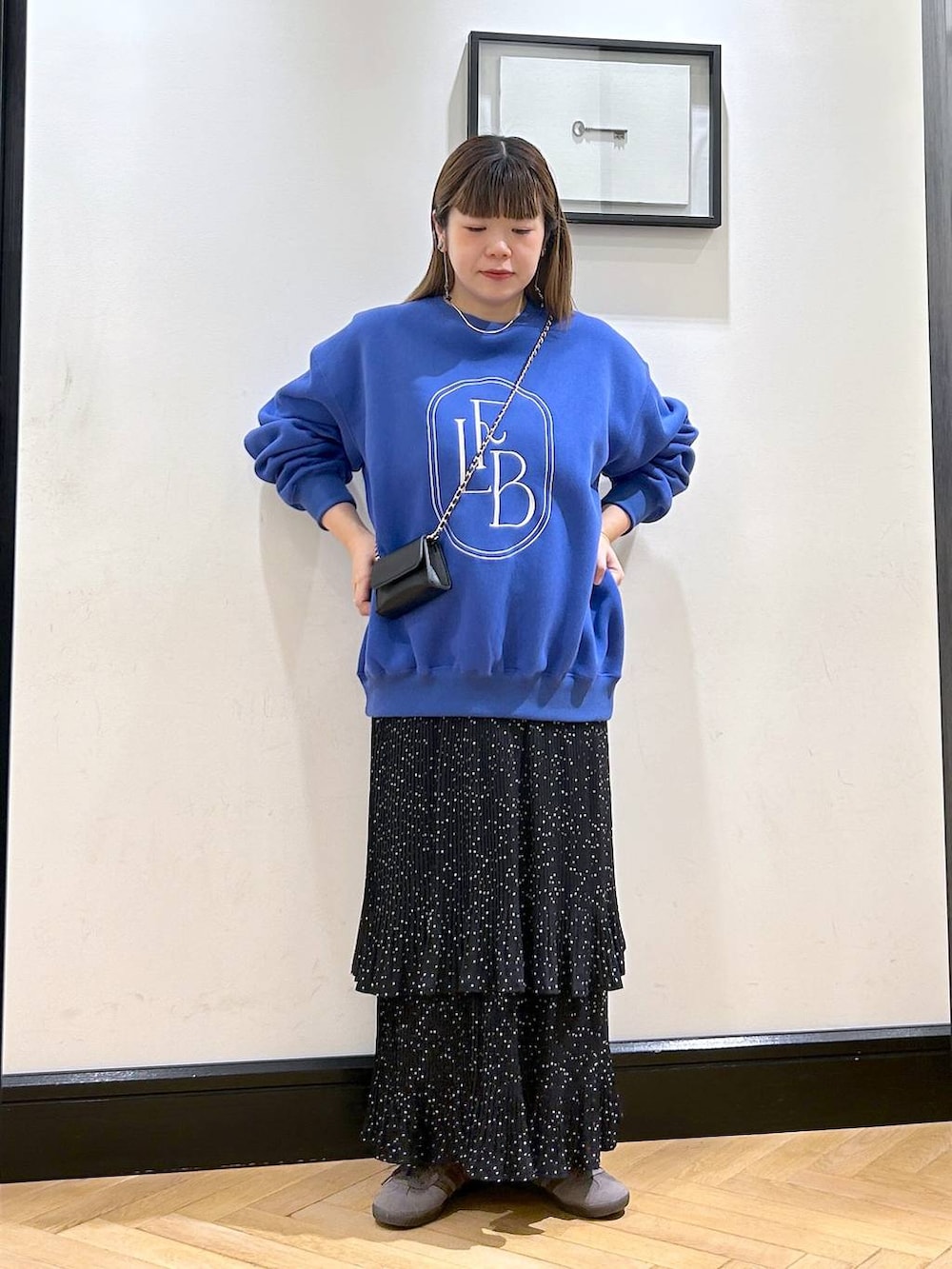 グレー系のスカート、グレー系のスニーカー、ブルー系のスウェットを着用したレディースの秋コーディネートの3枚目の写真