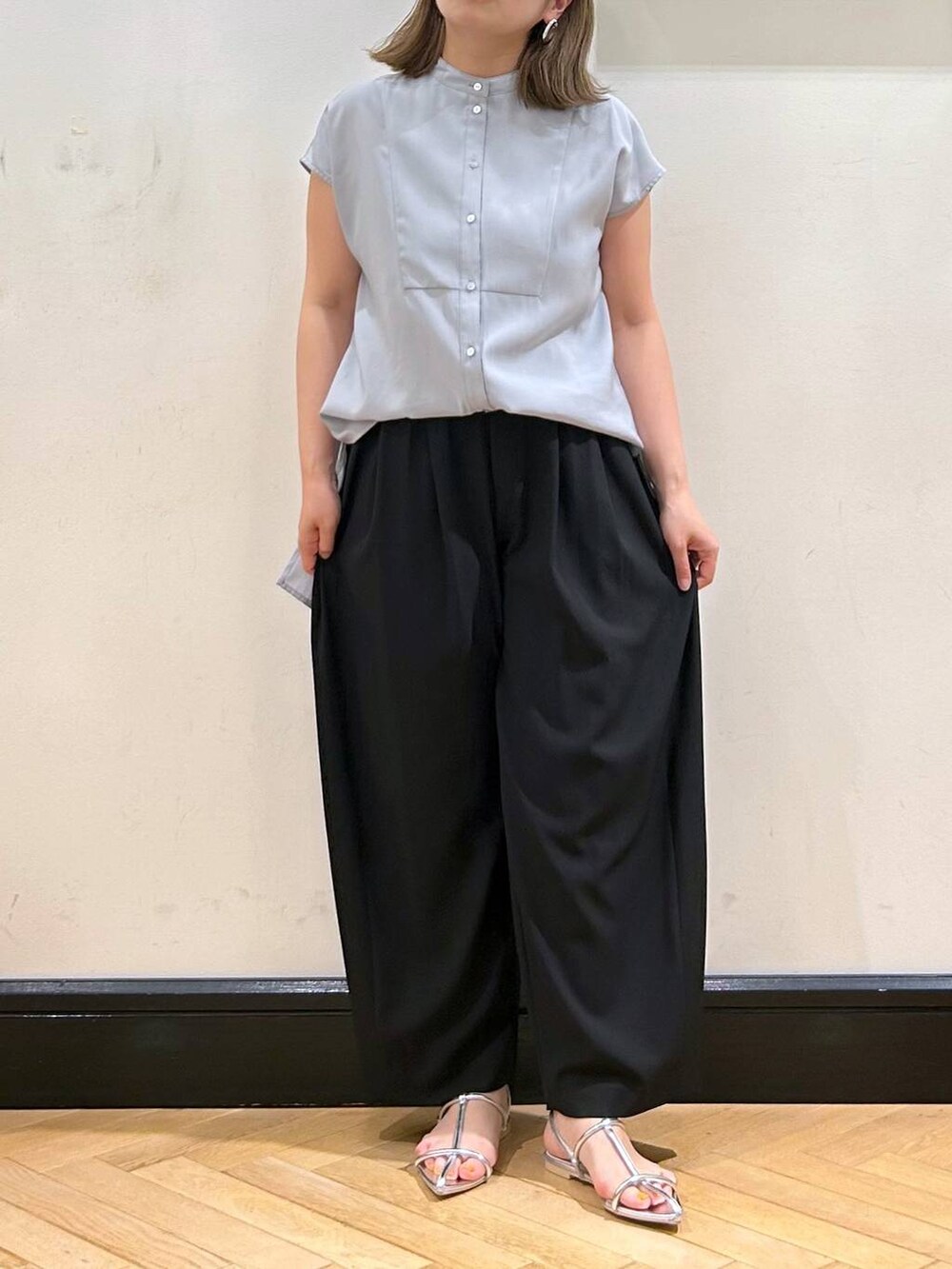 シルバー系のサンダル、ブラック系のスラックス、ブラック系のショルダーバッグを着用したレディースの夏コーディネートの8枚目の写真