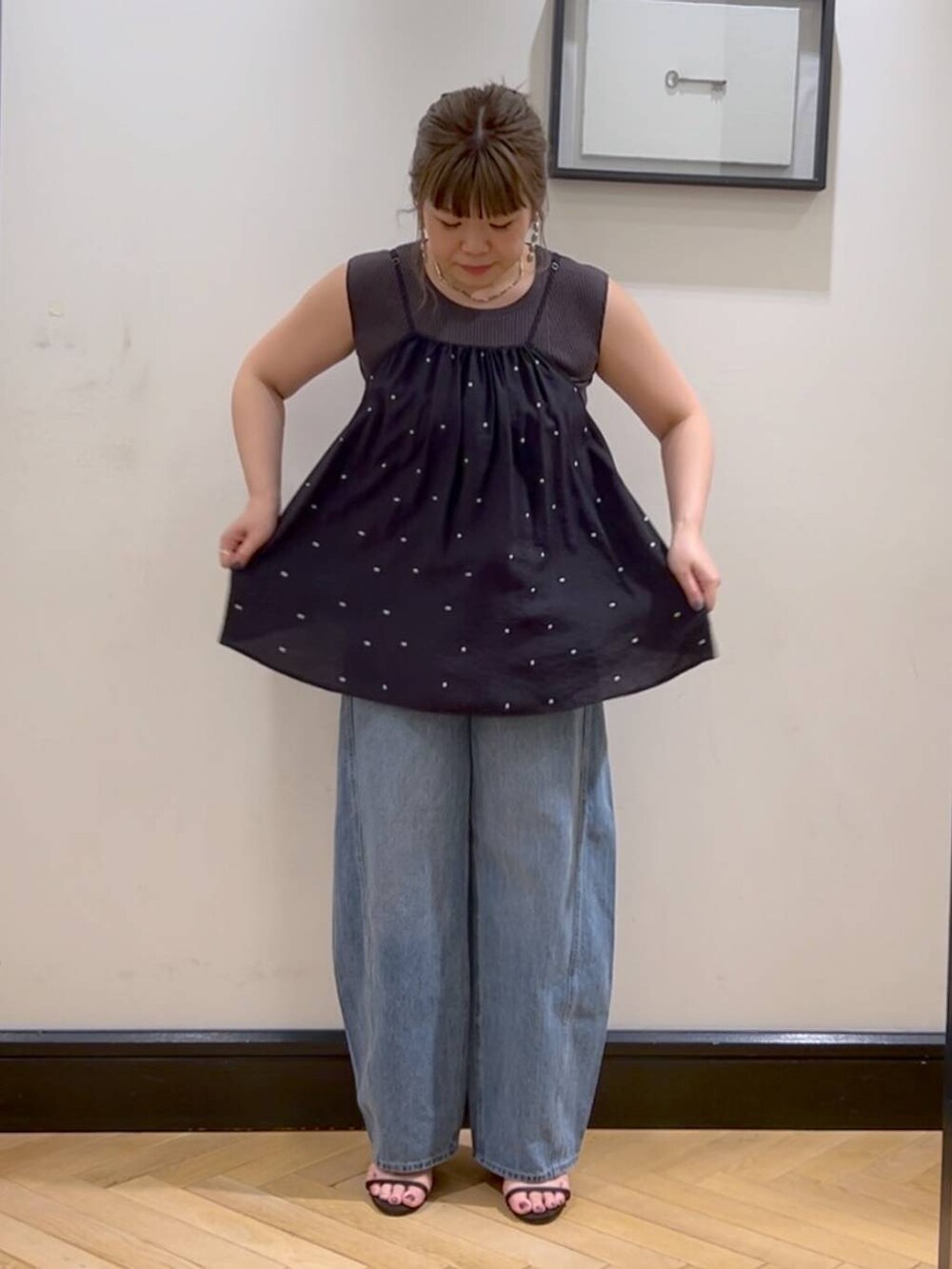 ブルー系のデニムパンツ、ブラウン系のサンダル、グレー系のタンクトップを着用したレディースの夏コーディネートの5枚目の写真