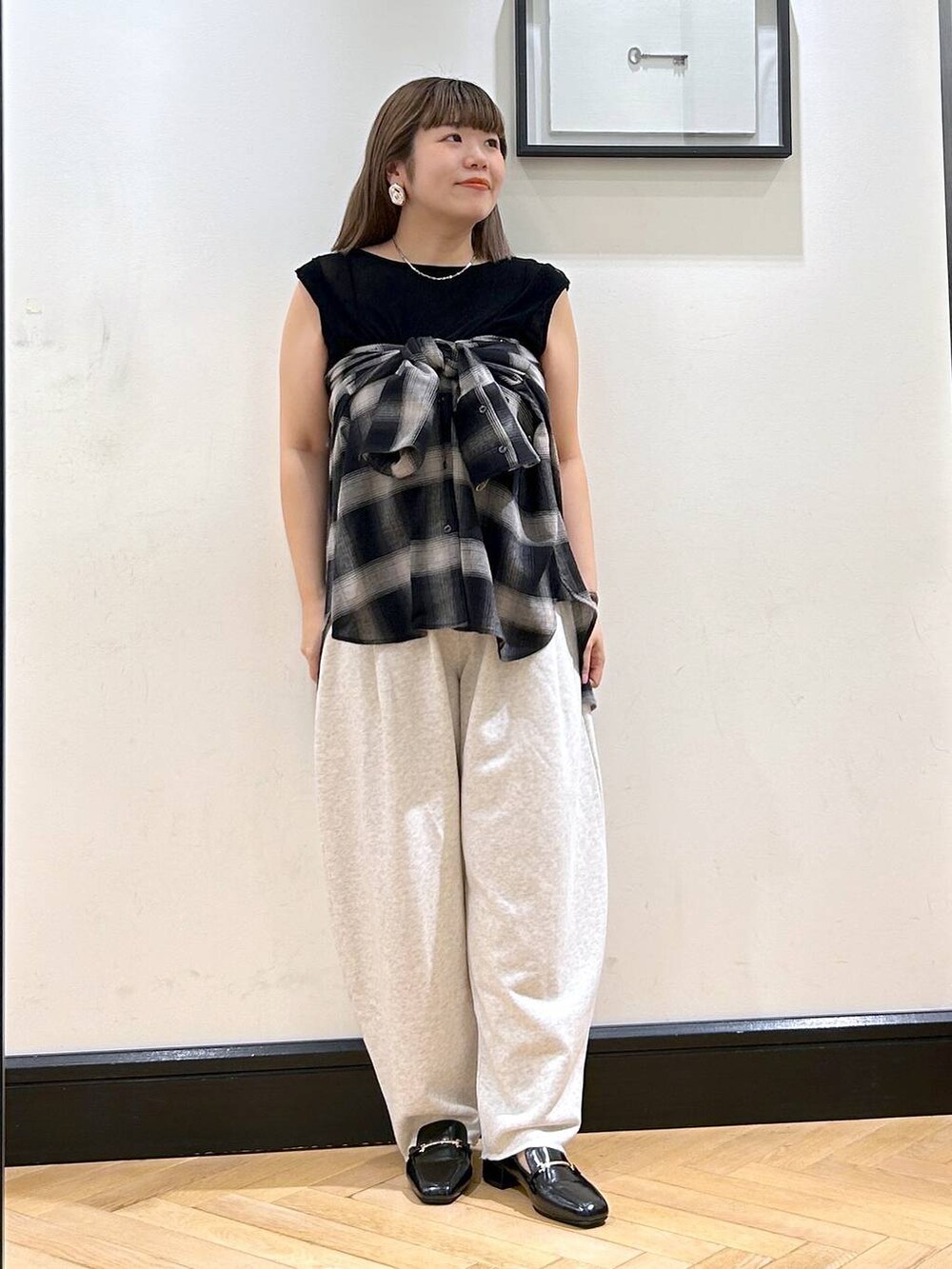ブラック系のローファー、グレー系のスウェットパンツ、ブラック系のTシャツ/カットソーを着用したレディースの夏コーディネートの5枚目の写真