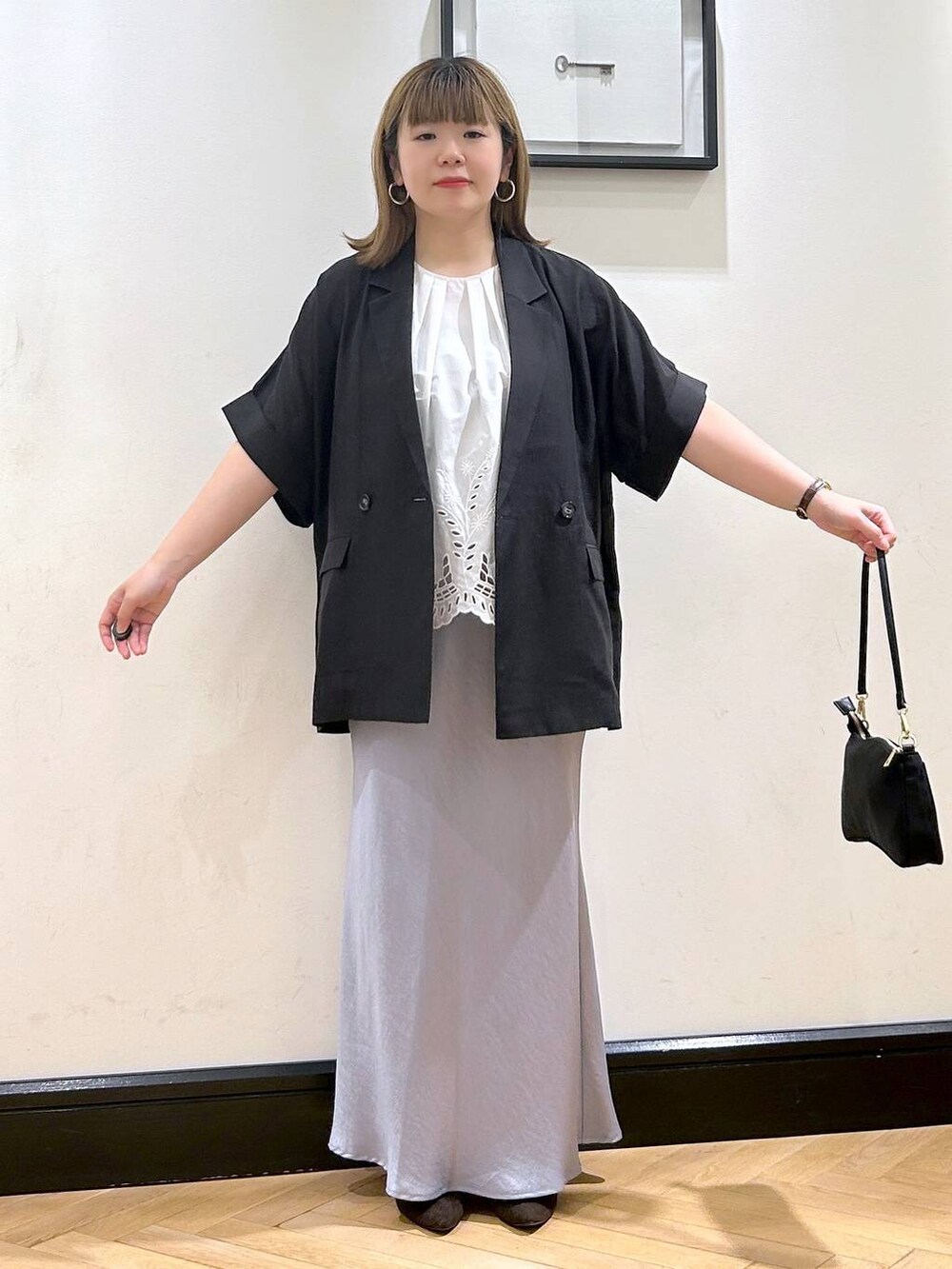 ブルー系のスカート、ブラウン系のパンプス、ホワイト系のシャツ/ブラウスを着用したレディースの夏コーディネートの4枚目の写真