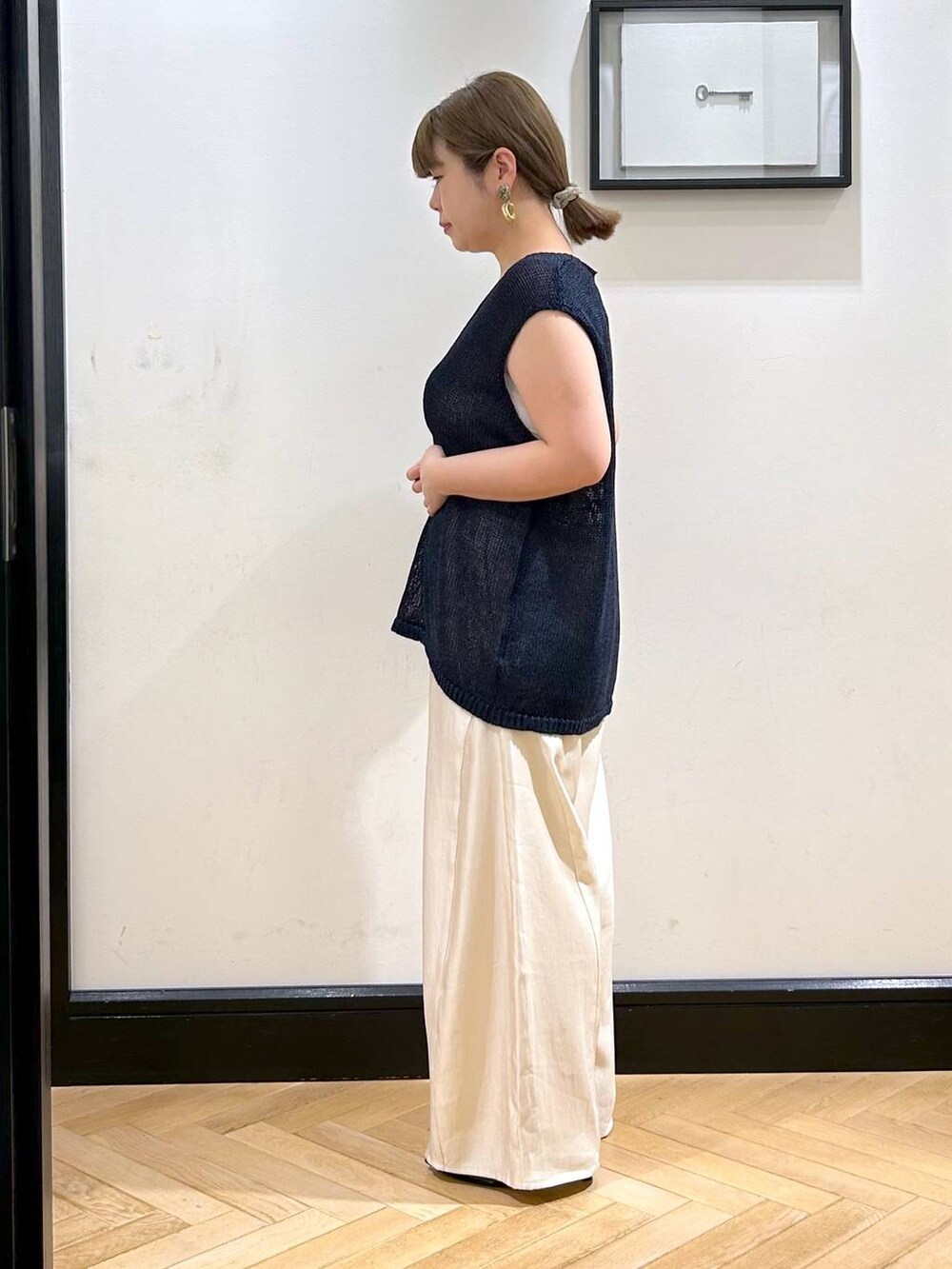 ブラック系のパンプス、ホワイト系のタンクトップ、ブラック系のボストンバッグを着用したレディースの夏コーディネートの7枚目の写真