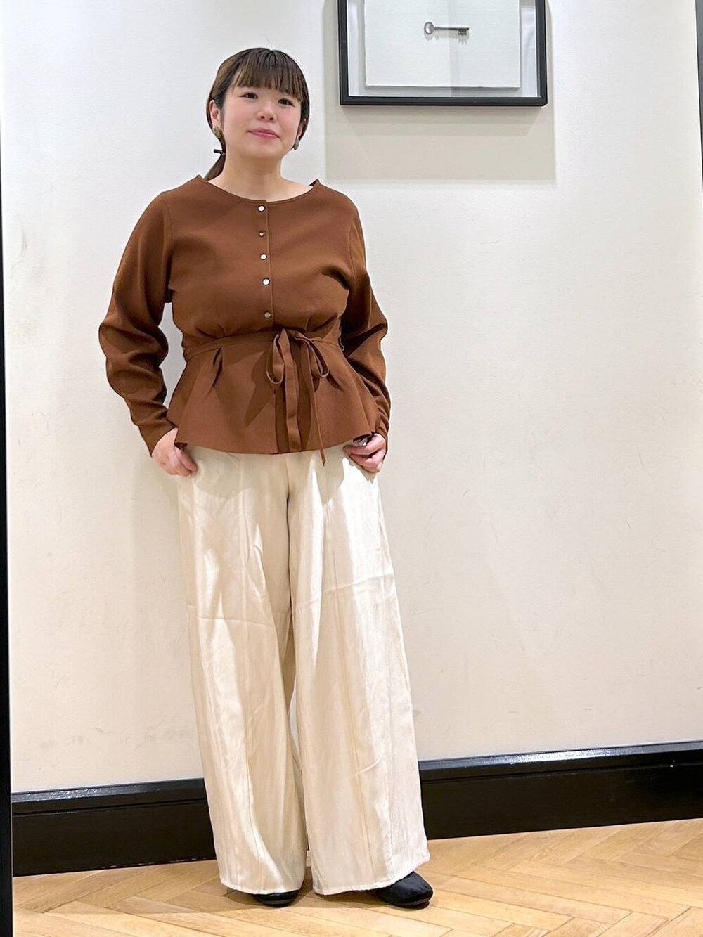 ホワイト系のその他パンツ、ブラック系のバレエシューズ、ブラウン系のカーディガン/ボレロを着用したレディースの秋コーディネートの2枚目の写真