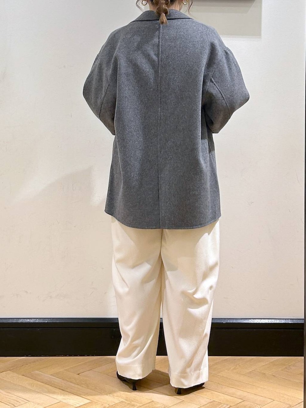 ホワイト系のスラックス、ブラウン系のパンプス、ブラック系のTシャツ/カットソーを着用したレディースの秋コーディネートの6枚目の写真