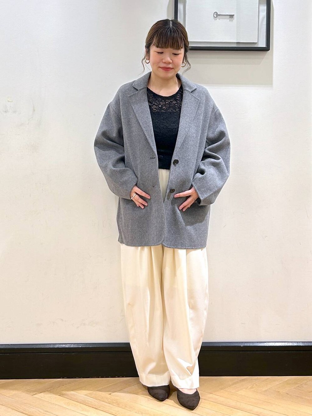 ホワイト系のスラックス、ブラウン系のパンプス、ブラック系のTシャツ/カットソーを着用したレディースの秋コーディネートの3枚目の写真