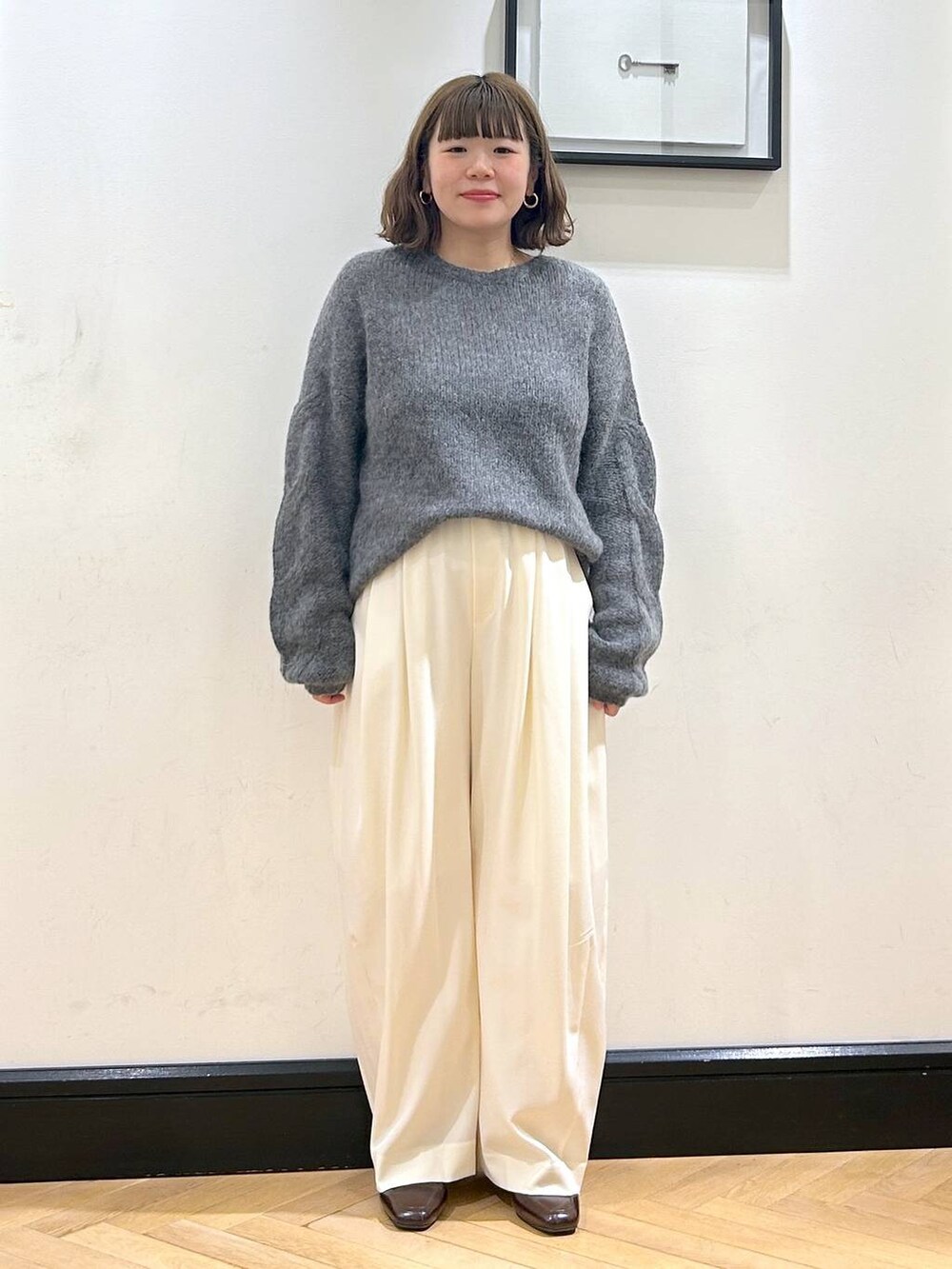 ホワイト系のスラックス、ブラウン系のローファー、グレー系のニット/セーターを着用したレディースの秋コーディネートの9枚目の写真
