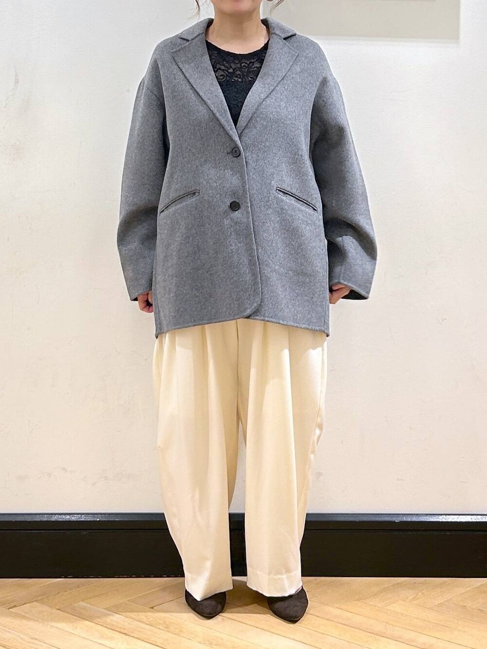 ホワイト系のスラックス、ブラウン系のパンプス、ブラック系のTシャツ/カットソーを着用したレディースの秋コーディネートの8枚目の写真