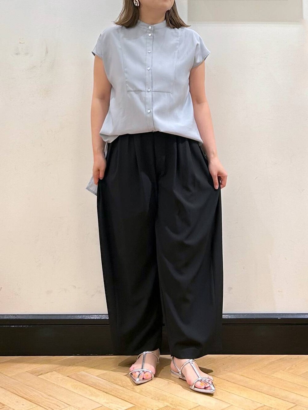 シルバー系のサンダル、ブラック系のスラックス、ブラック系のショルダーバッグを着用したレディースの夏コーディネートの7枚目の写真