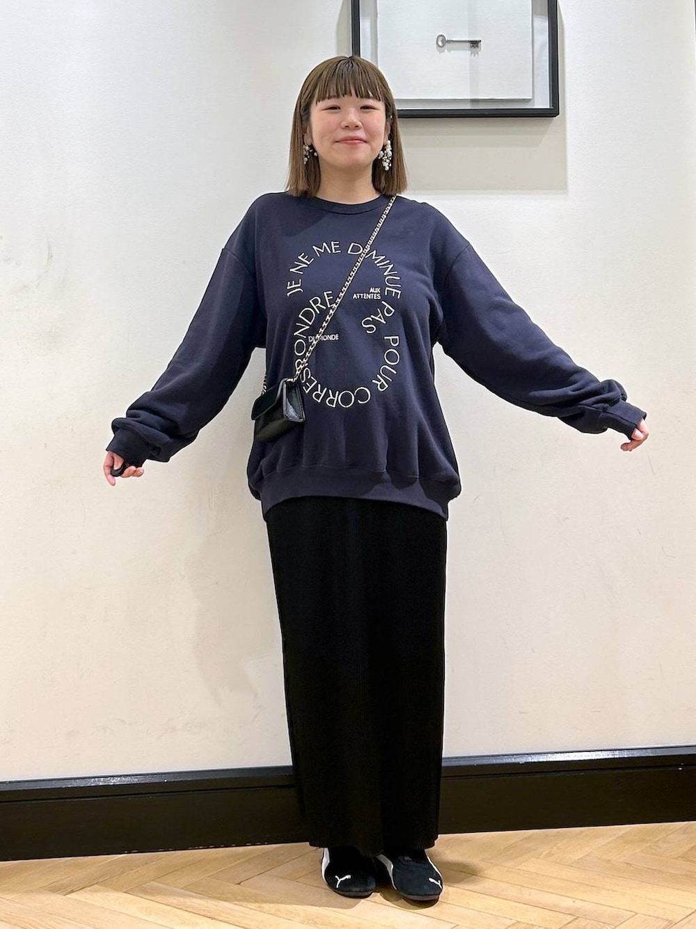 ブラック系のスニーカー、ブラック系のスカート、ブルー系のスウェットを着用したレディースの秋コーディネートの2枚目の写真