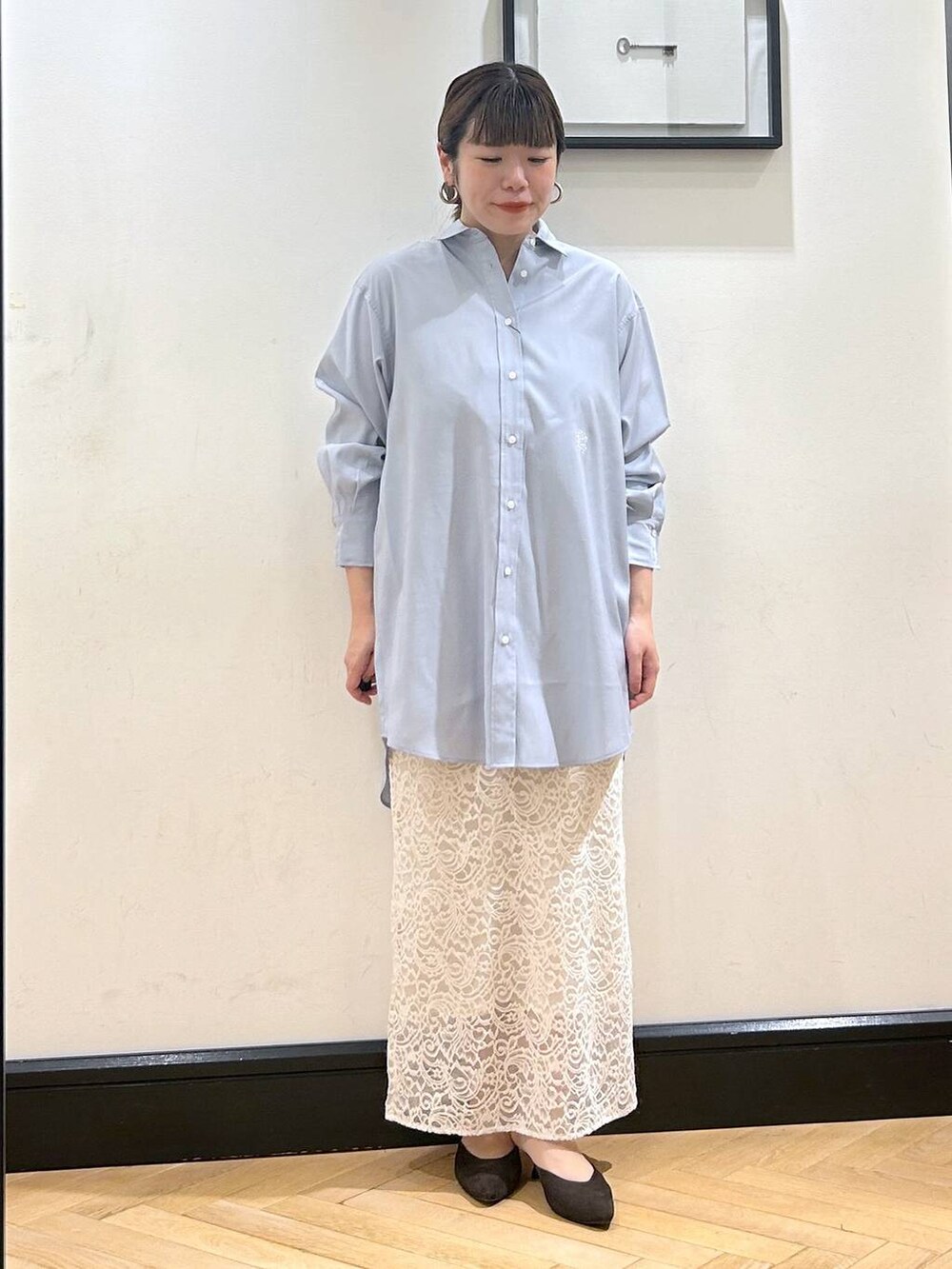 ブラウン系のパンプス、ホワイト系のスカート、ブルー系のシャツワンピースを着用したレディースの秋コーディネートの3枚目の写真