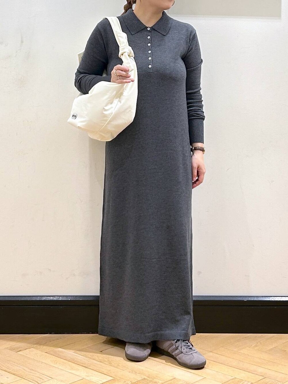 グレー系のスニーカー、ホワイト系のトートバッグ、グレー系のワンピースを着用したレディースの秋コーディネートの6枚目の写真