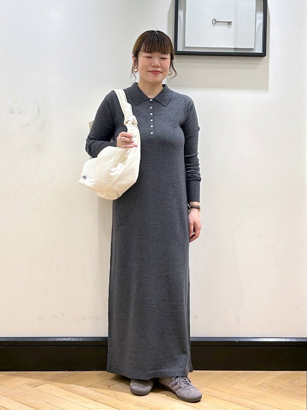 グレー系のスニーカー、ホワイト系のトートバッグ、グレー系のワンピースを着用したレディースの秋コーディネートの5枚目の写真