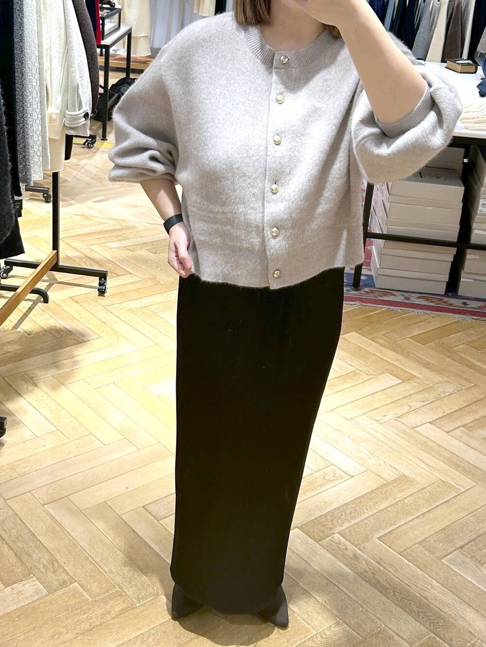 ブラック系のスカート、ベージュ系のカーディガン/ボレロ、ブラウン系のブーツを着用したレディースの秋コーディネートの7枚目の写真