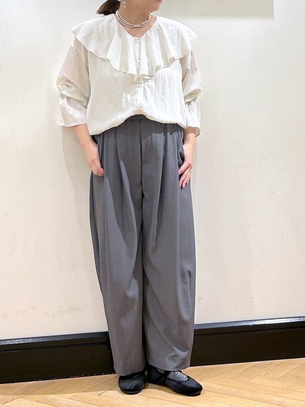 グレー系のスラックス、ブラック系のバレエシューズ、ホワイト系のシャツ/ブラウスを着用したレディースの秋コーディネートの8枚目の写真