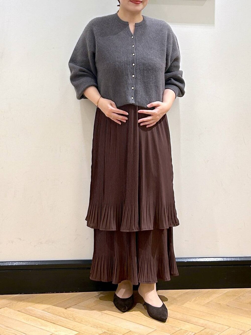 ブラウン系のスカート、グレー系のカーディガン/ボレロ、ブラウン系のパンプスを着用したレディースの秋コーディネートの4枚目の写真