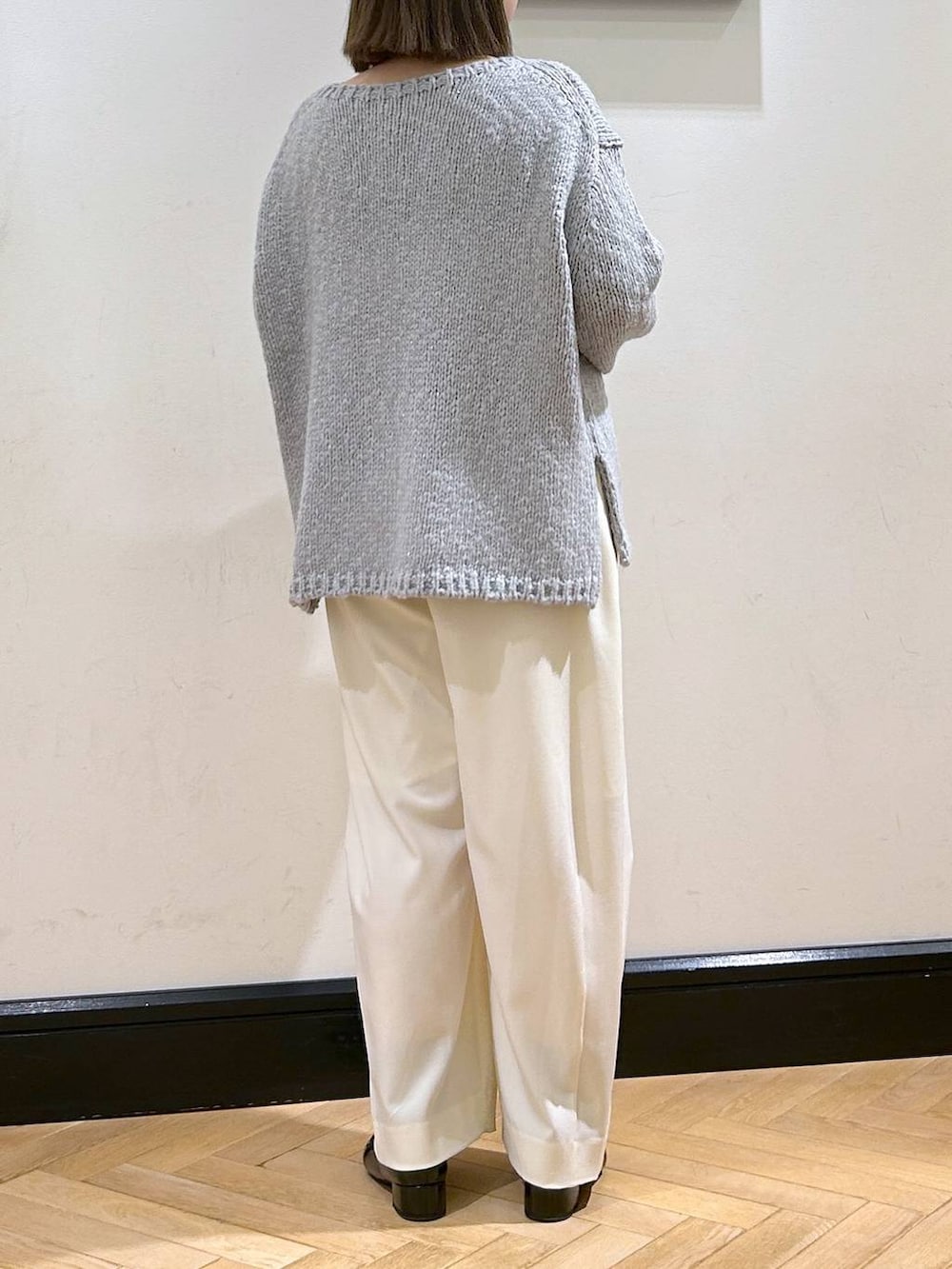 ホワイト系のスラックス、ブラック系のローファー、グレー系のニット/セーターを着用したレディースの秋コーディネートの6枚目の写真